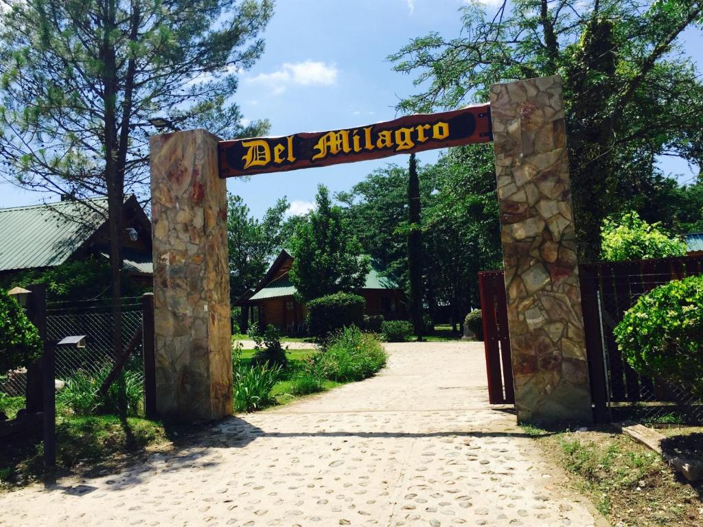 a gate to a garden with a sign that reads el albuquerque at Del Milagro Cabañas & Posada in Villa General Belgrano