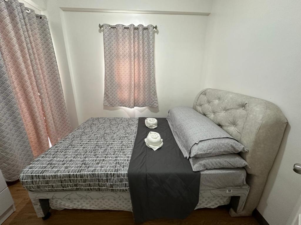 een slaapkamer met een bed, een stoel en een tafel bij Cozy Condo Almond drive 1BR Talisay SRP w pool in Tangke