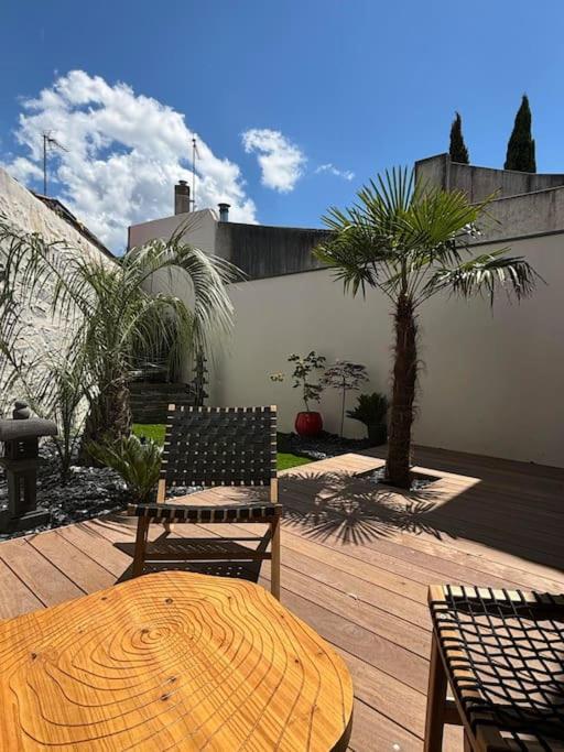 une table et des chaises en bois sur une terrasse en bois dans l'établissement L'Escale Maison de caractère quartier Saint Michel, à Les Sables-dʼOlonne