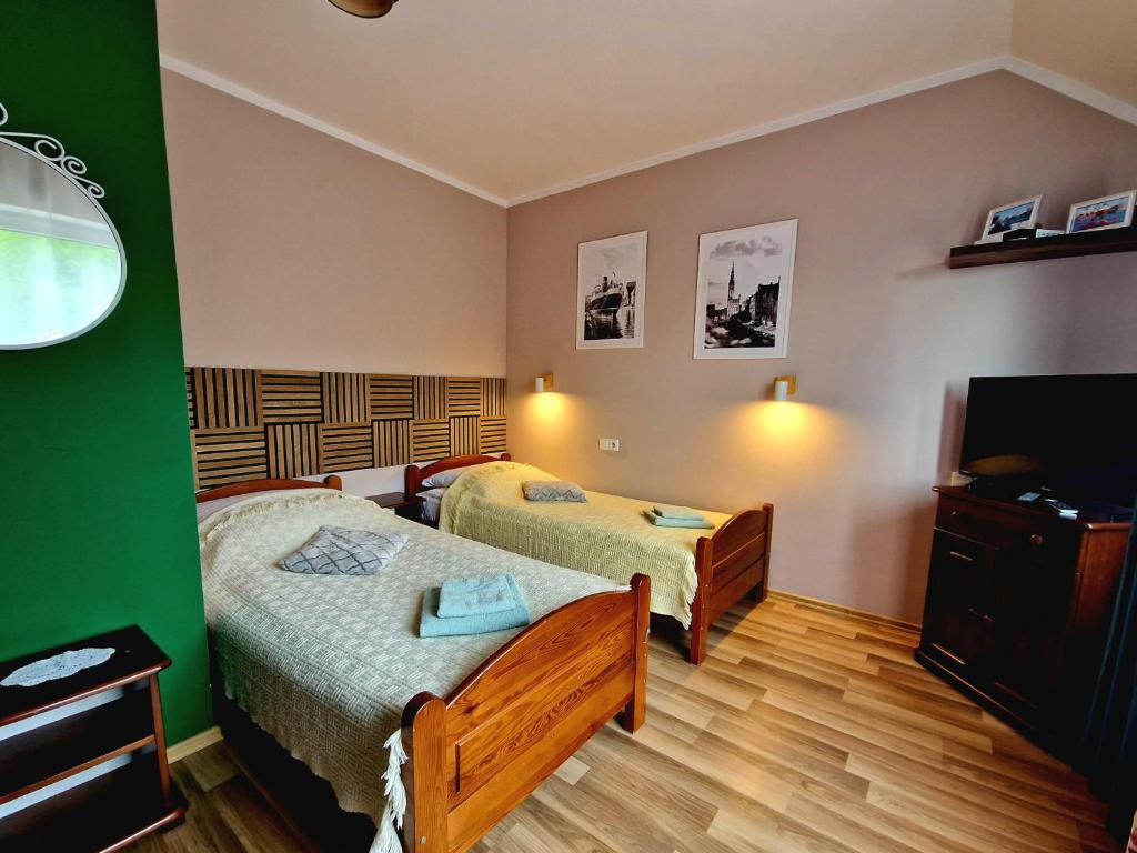 a hotel room with two beds and a television at Willa Bliska in Gdańsk