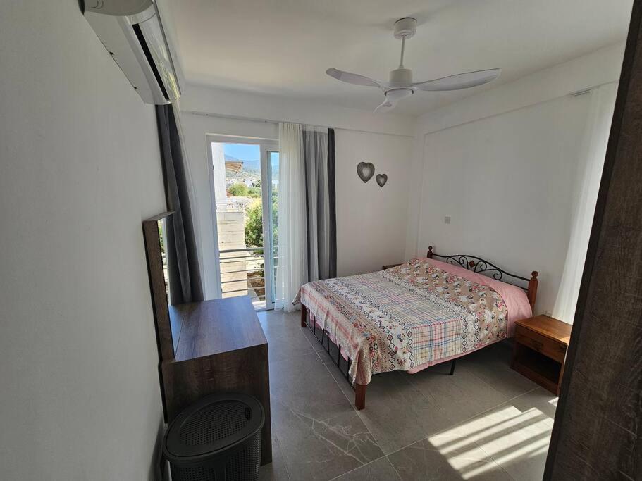 ein Schlafzimmer mit einem Bett und einem Tisch und einem Fenster in der Unterkunft Tranquil Penthouse Apartment Turtle Bay Village Esentepe in Ayios Yeoryios