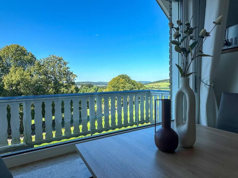 a balcony with two vases and a window with a view at Bovenappartement in Winterberg met balkon en uitzicht over het bos in Winterberg