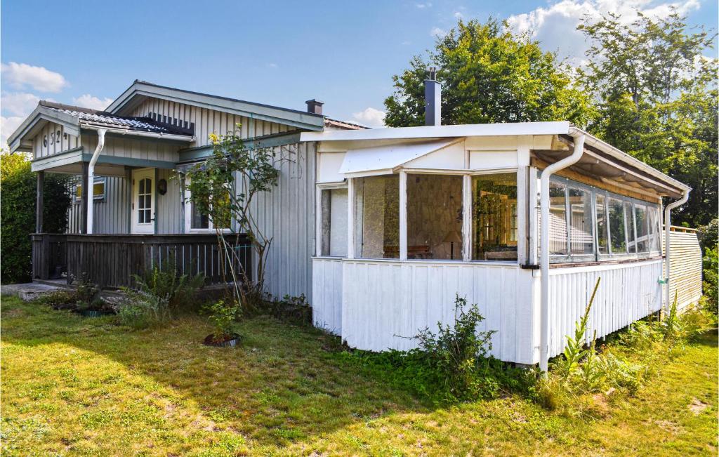 a small white house with a lot of windows at Cozy Home In Sölvesborg With Kitchen in Sölvesborg