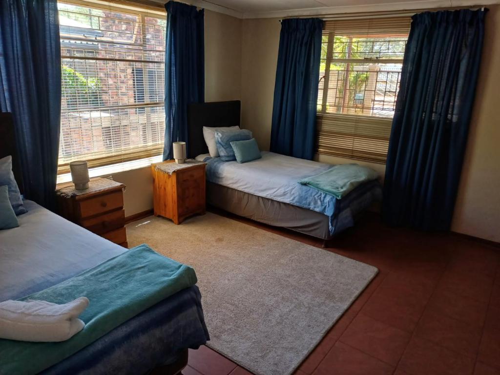 a bedroom with two beds and a window at Susanna's Self catering 2 bedroom apartment in Kimberley
