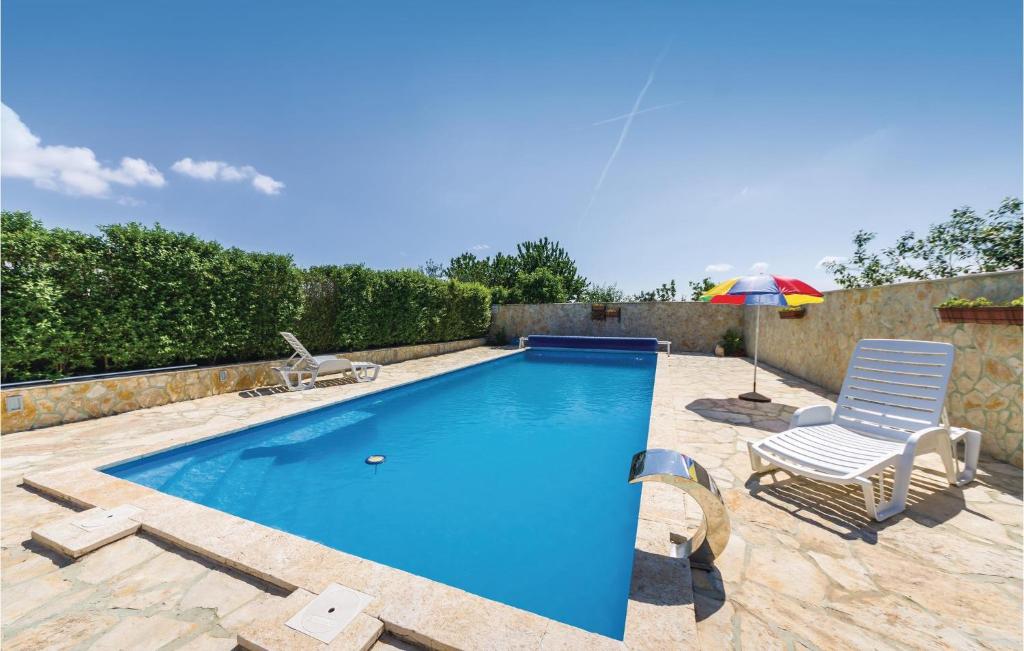 una piscina con una silla y una sombrilla en Beautiful Apartment In Vrana With Wifi, en Vrana