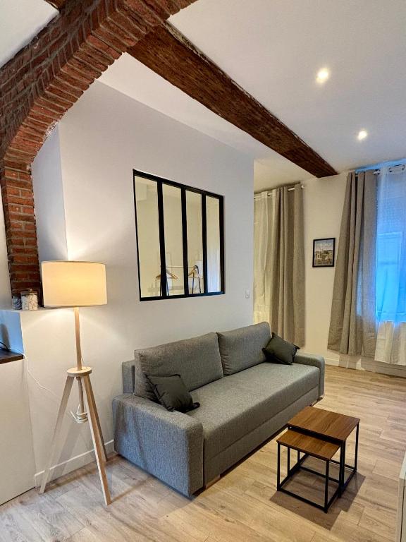 un salon avec un canapé et une table dans l'établissement Le Petit Hainaut, hyper centre, à Valenciennes