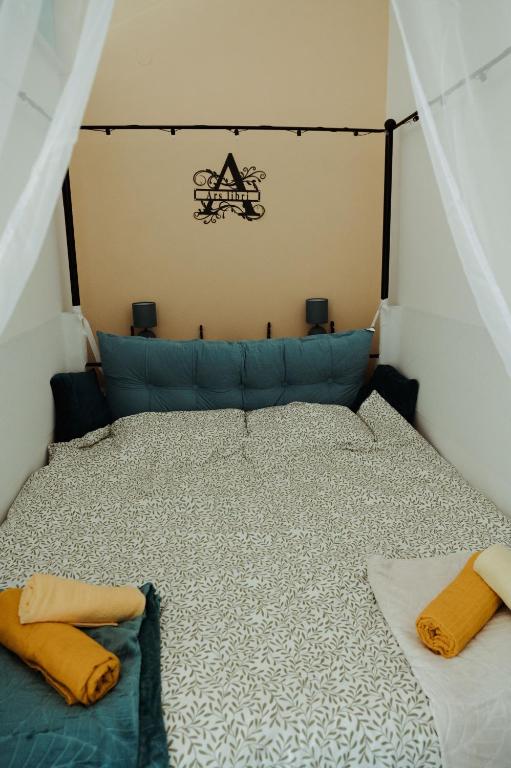 a bedroom with a bed with a blue couch at Studio apartman Ars libri in Đakovo