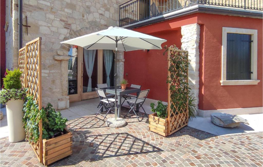 a patio with a table and an umbrella at Nice Home In Marano Di Valpolicella in Marano di Valpolicella