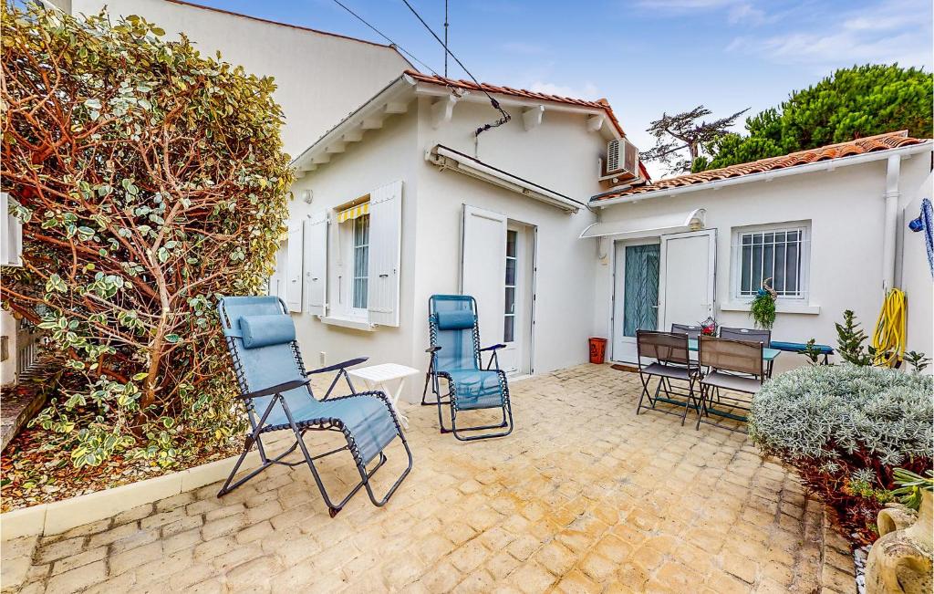 patio z krzesłami i stołem oraz dom w obiekcie 2 Bedroom Gorgeous Home In Royan w mieście Royan