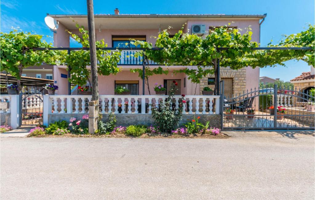 a white fence in front of a house at Amazing Apartment In Biograd Na Moru in Biograd na Moru