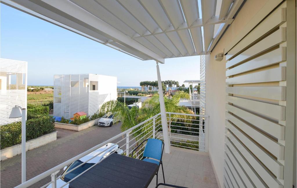 einen Balkon mit einer Bank und Meerblick in der Unterkunft Cozy Home In Marina Di Ragusa With Wifi in Marina di Ragusa