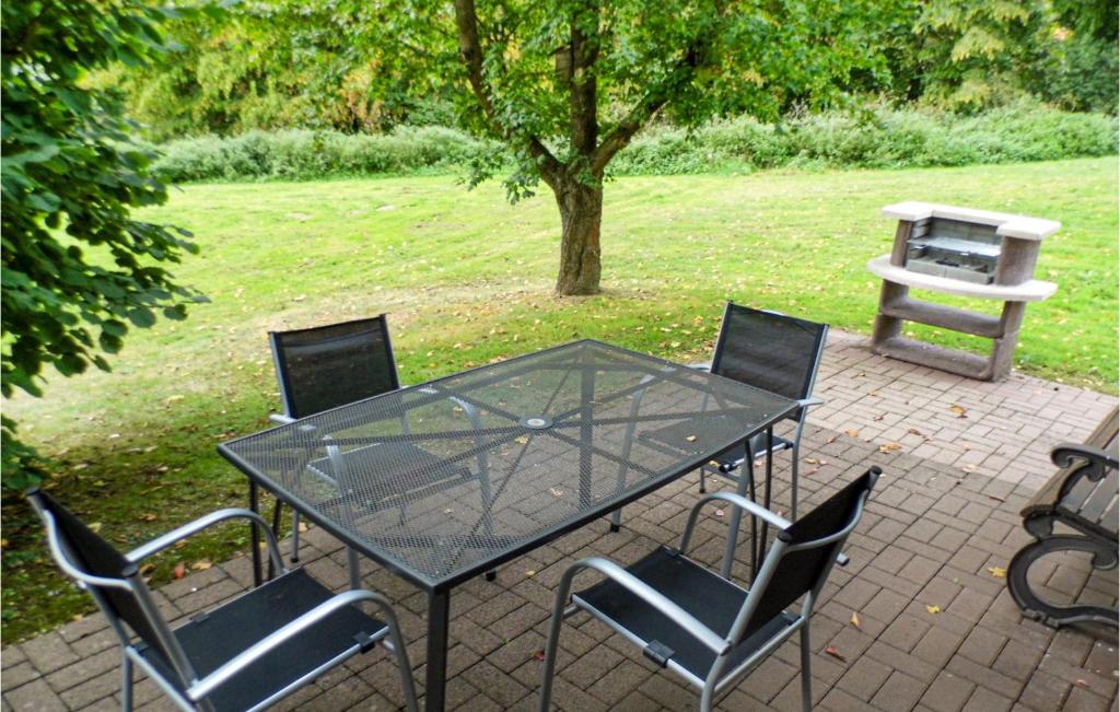 a glass table and chairs on a brick patio at 3 Bedroom Beautiful Home In Kirchheim in Kirchheim