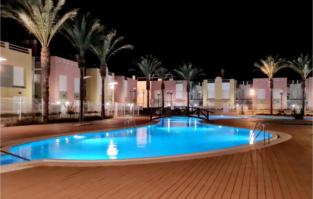 una gran piscina por la noche con palmeras en Charming Apartment With Pool, en Vera