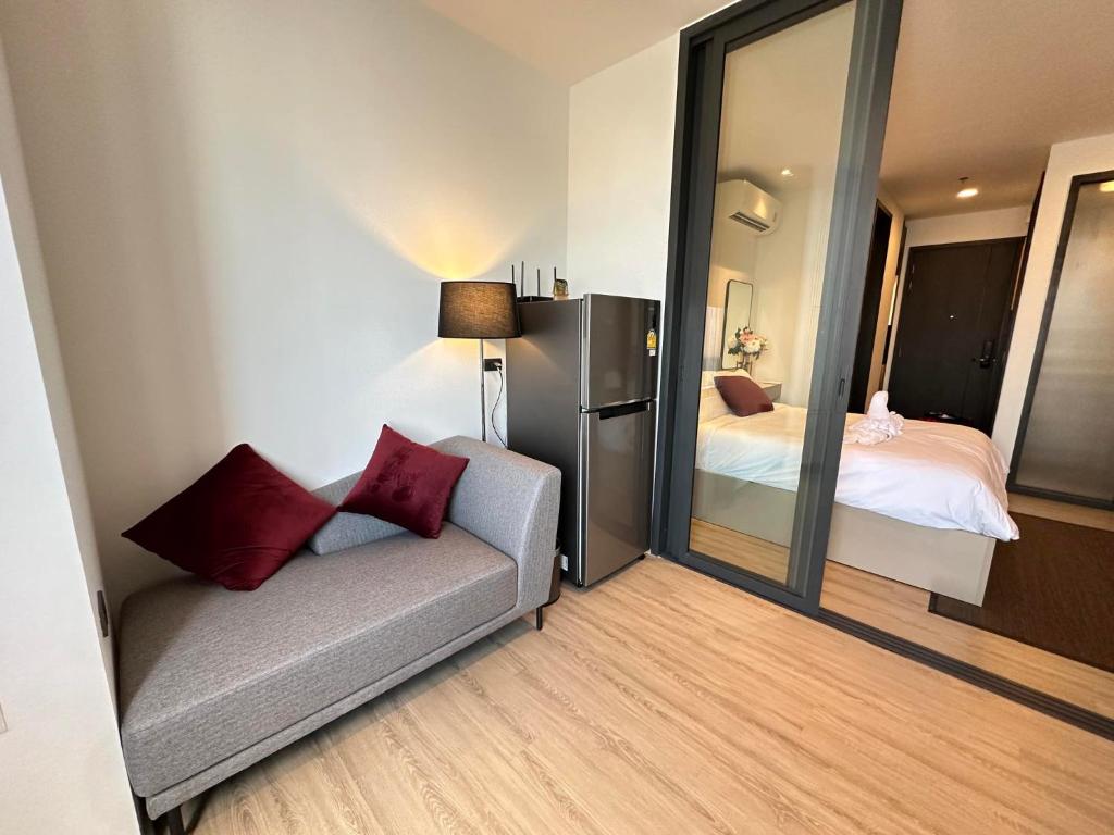 a small room with a couch and a bedroom at Edge centarl pattaya luxury sea view in Ban Khok Kham