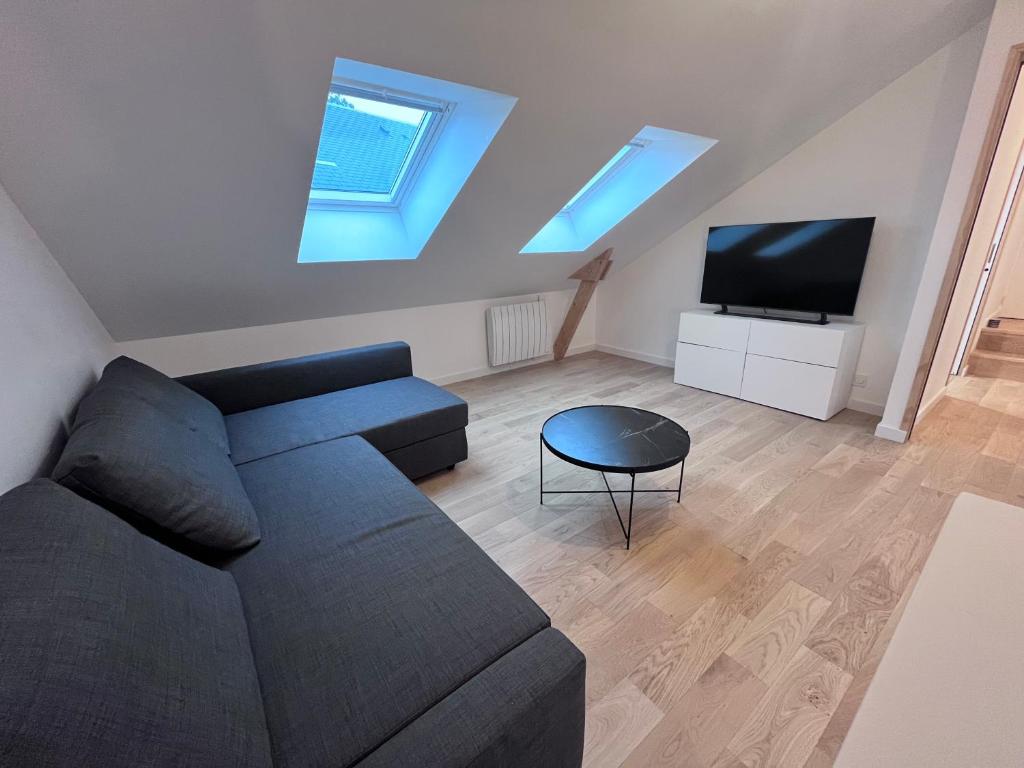 a living room with a couch and a tv at Appartement Lancieux in Lancieux