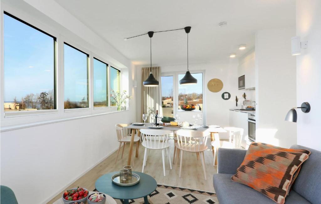 ein weißes Wohnzimmer mit Tisch und Stühlen in der Unterkunft Cozy Apartment In Lembruchdümmer See in Lembruch