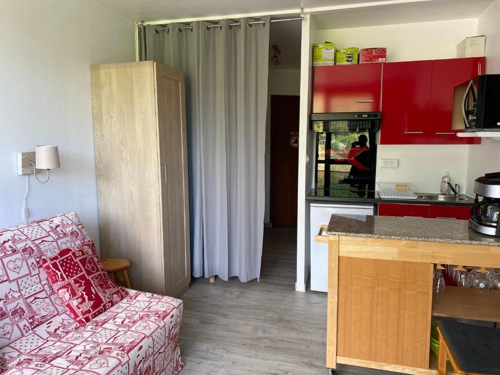 a living room with a couch and a kitchen at Studio aux pieds des pistes in Villard-de-Lans