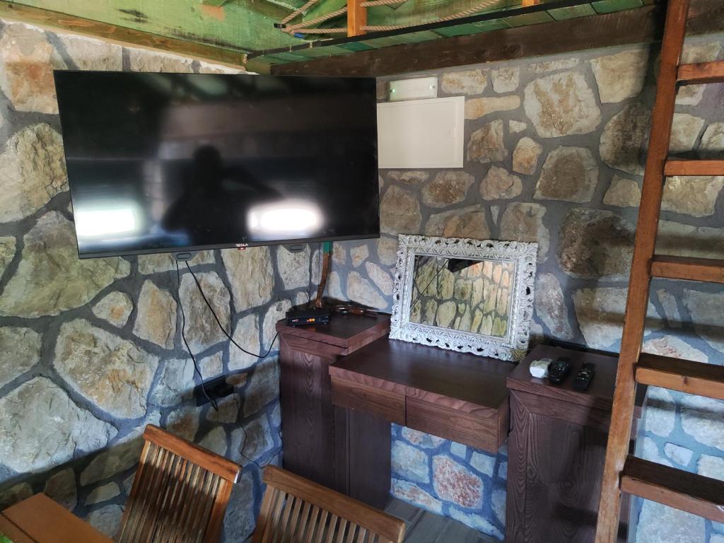 a television on a stone wall in a room at Stone House Montenegro in Danilovgrad