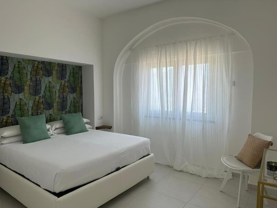una camera da letto bianca con un letto grande e una finestra di Chez Moira apartment with seaview a Ravello