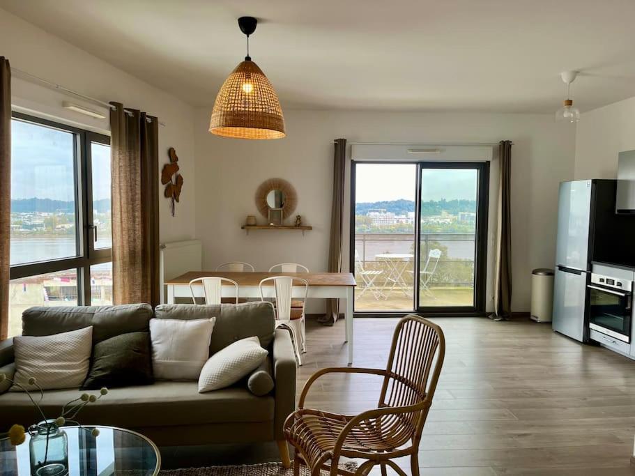 un salon avec un canapé et une table avec des chaises dans l'établissement Appartement proche de la gare - 80m2, à Bordeaux