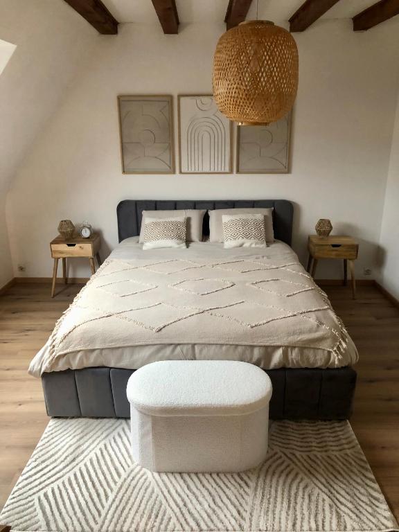- une chambre avec un grand lit et un pouf dans l'établissement Appartement cosy 2-4 personnes, à Leutenheim