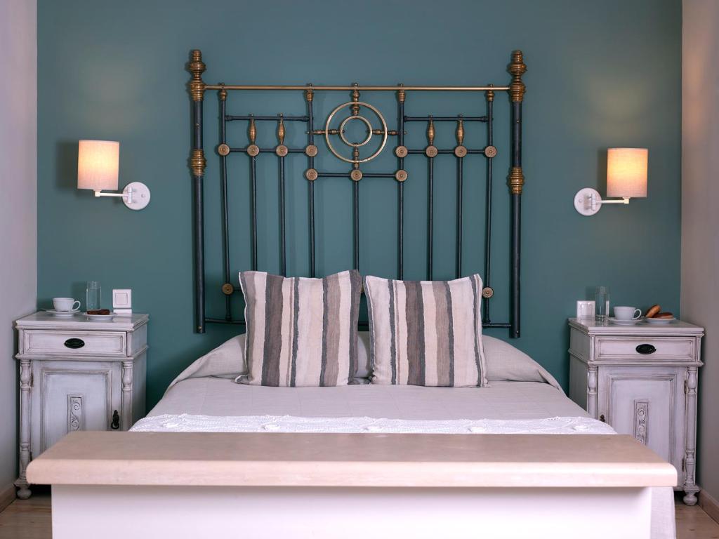 a bed with a green headboard and two night stands at Mythos Suites Boutique Hotel in Rethymno