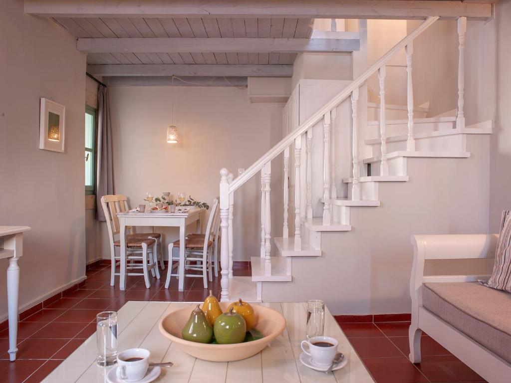 a living room with a table with a bowl of fruit at Mythos Suites Boutique Hotel in Rethymno