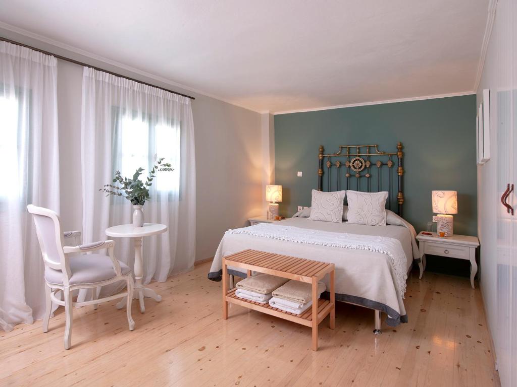 a bedroom with a bed and a table and a chair at Mythos Suites Boutique Hotel in Rethymno