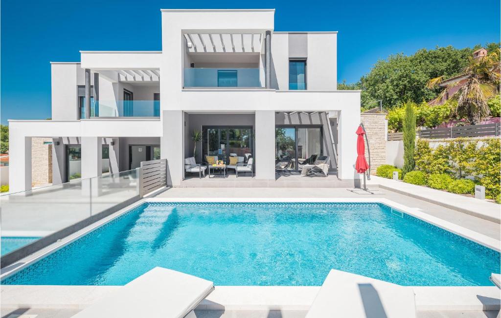 una villa con piscina frente a una casa en 3 Bedroom Gorgeous Home In Medulin, en Medulin
