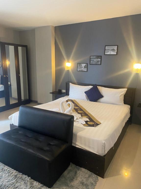 a bedroom with a large bed and a chair at Holiday Home Patong in Patong Beach