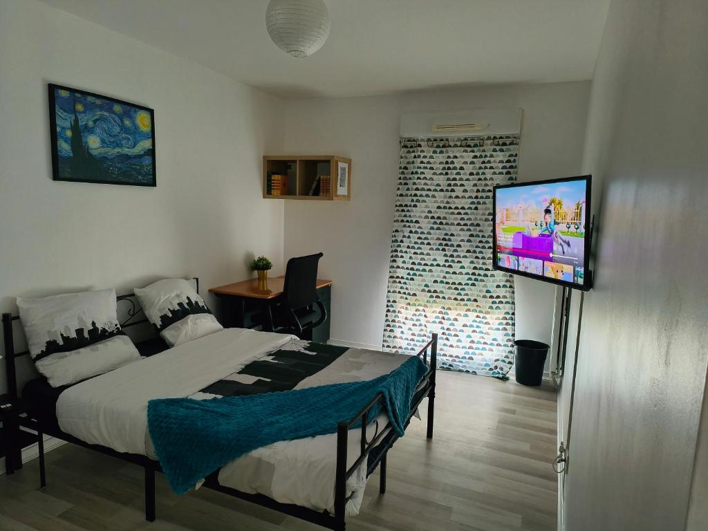 a bedroom with a bed and a flat screen tv at Chambre privée proche stade de France et Paris dans appartement partagé in Pierrefitte-sur-Seine
