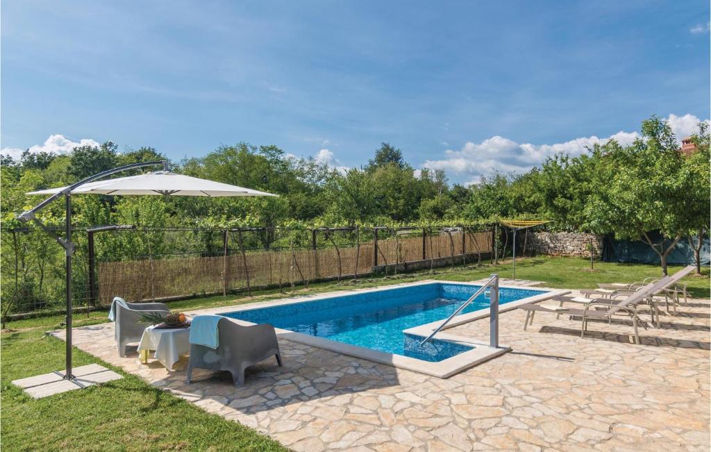 basen z dwoma krzesłami i parasolem w obiekcie Holiday Home Cere Cere Ii w mieście Santalezi