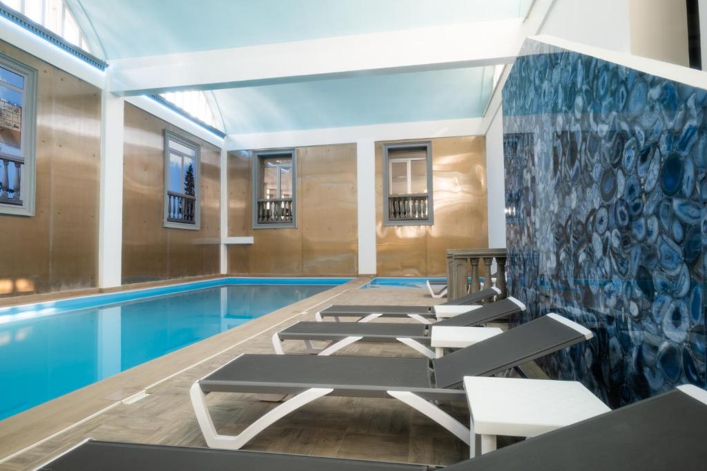 una sala con piscina e sedie a sdraio di Hotel Mio City a Kula