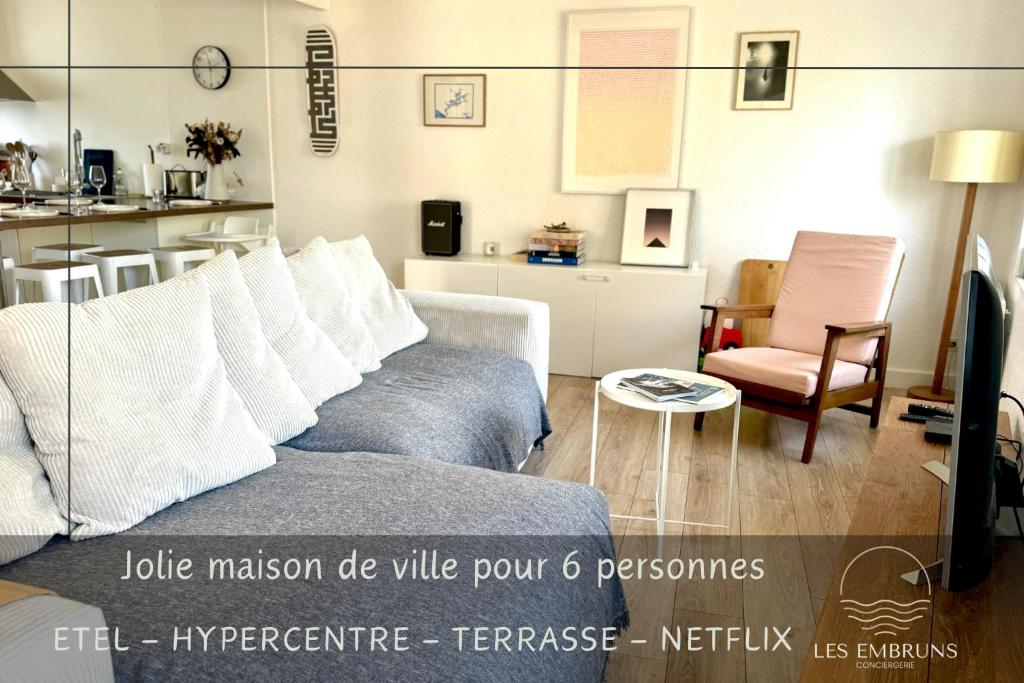 a living room with a couch and a table at Maison de pêcheurs a 100m de l'océan! in Étel