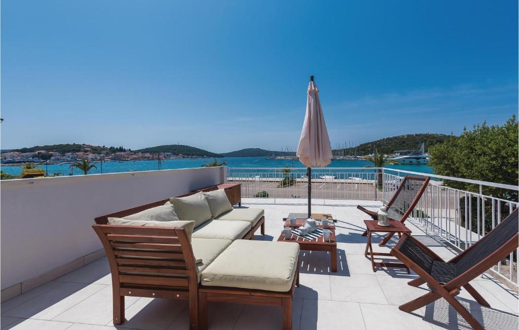 a patio with a couch and chairs and an umbrella at Three-Bedroom Apartment In Rogoznica in Rogoznica