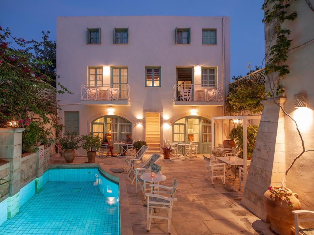 a house with a swimming pool in front of a building at Mythos Suites Boutique Hotel in Rethymno