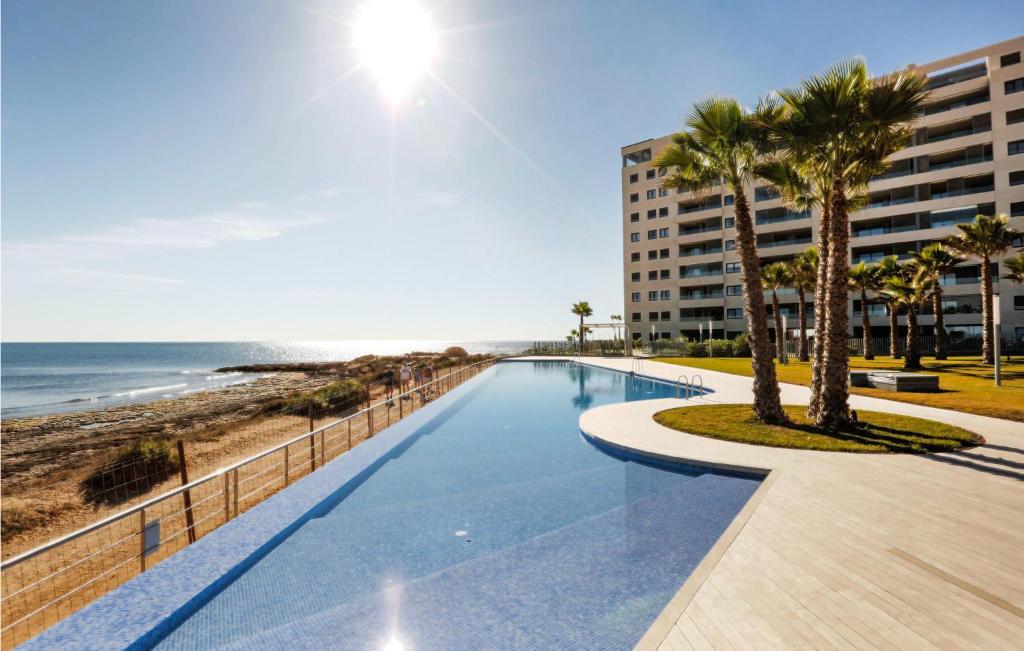 ein Schwimmbad neben einem Strand und einem Gebäude in der Unterkunft Amazing Apartment - Torrevieja in Torrevieja