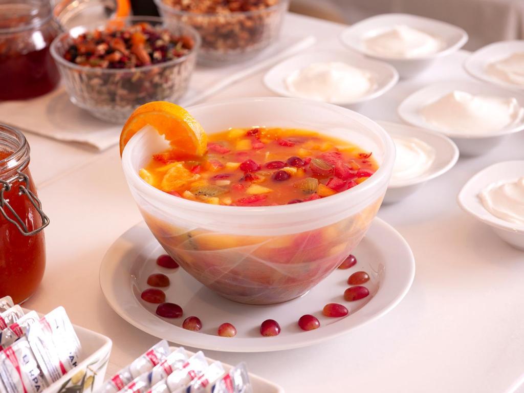 a bowl of soup on a plate on a table at Mythos Suites Boutique Hotel in Rethymno