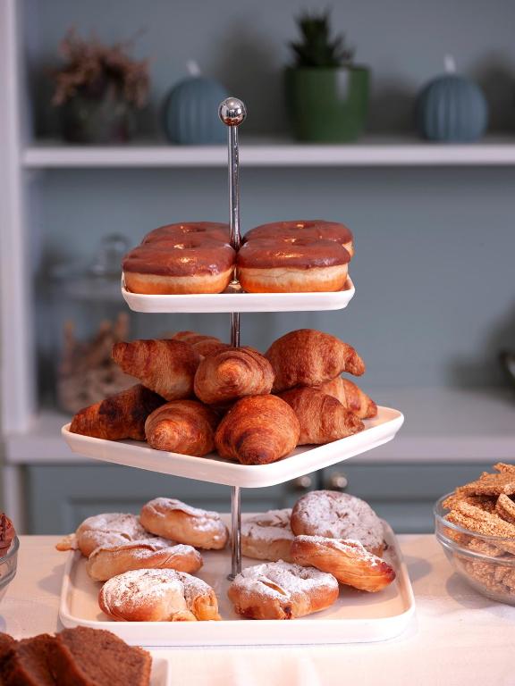 a three tiered display of donuts and other pastries at Mythos Suites Boutique Hotel in Rethymno
