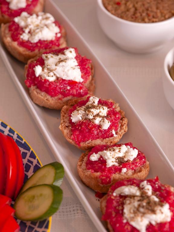 a tray with four pieces of bread with jam and cheese at Mythos Suites Boutique Hotel in Rethymno