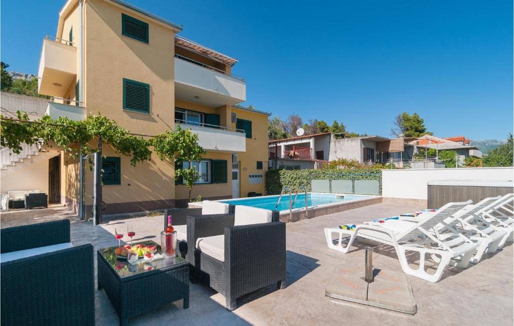索林Studio Apartment In Solin的一个带桌椅的露台和一个游泳池