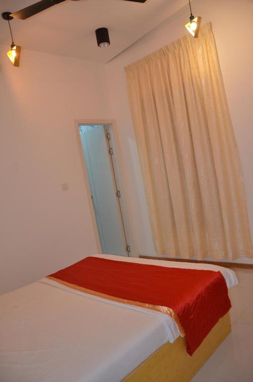 a bedroom with a bed with a red blanket on it at PRIV Fodhdhoo in Fodhdhoo