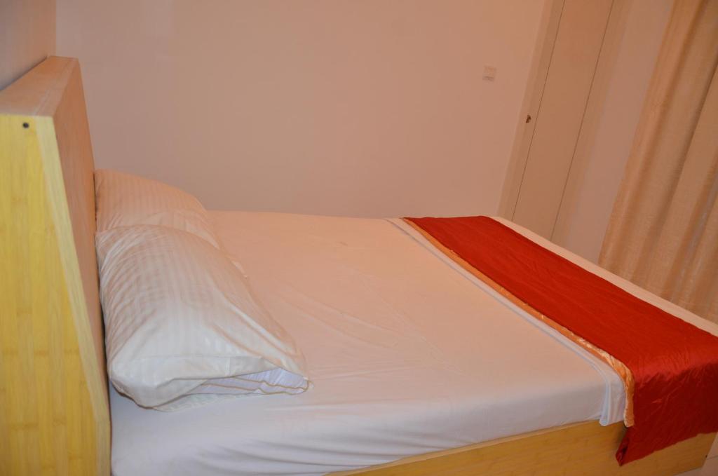 a white bed with a red blanket on top of it at PRIV Fodhdhoo in Fodhdhoo
