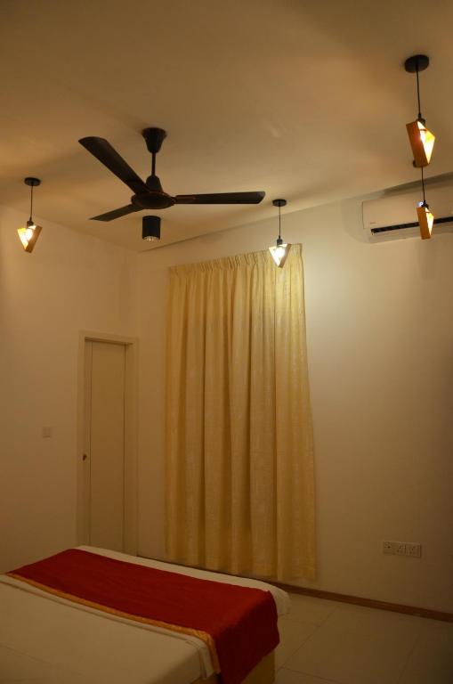 a bedroom with a bed and a ceiling fan at PRIV Fodhdhoo in Fodhdhoo