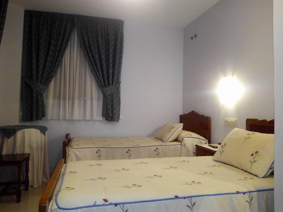 A bed or beds in a room at Hostal Pumar