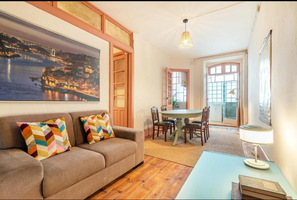 ein Wohnzimmer mit Sofa und Tisch in der Unterkunft Casa do Alfaiate Séc XIX in Porto