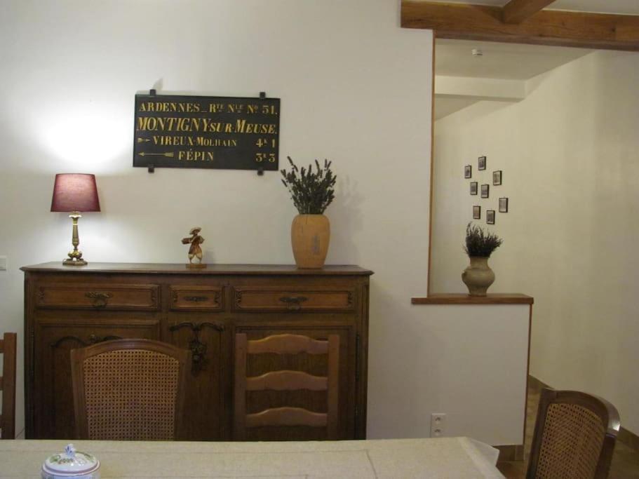 a dining room with a table and a sign on the wall at Au Val Heureux, meublé 3 étoiles, Clévacances in Haybes
