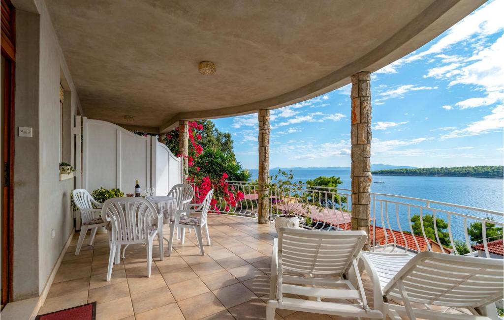 balkon z białymi krzesłami i widokiem na wodę w obiekcie Apartment Prizba - 05 w mieście Prižba