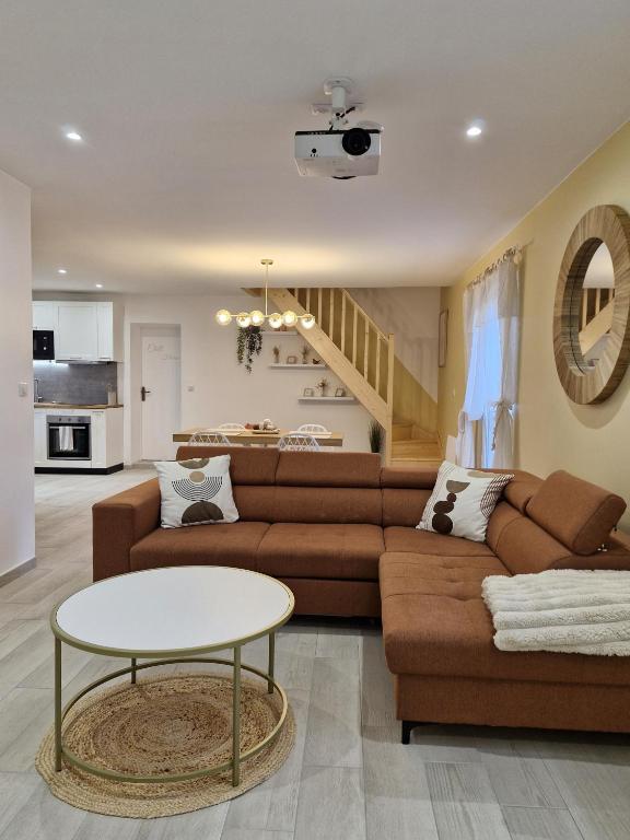 a living room with a couch and a table at Chill House - Maison 2 chambres - Option Jacuzzi in Chevannes