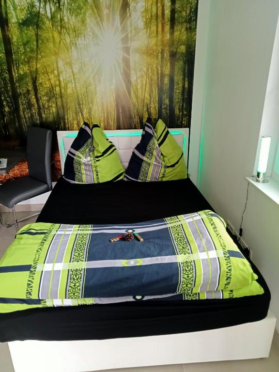 a bed with a blue and yellow comforter and pillows at Ferienzimmer Waldzauber in Borkwalde
